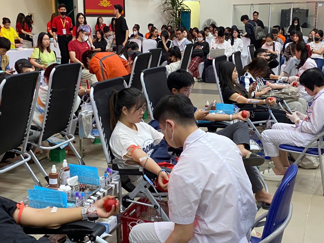 A busy voluntary blood donation event in Hanoi with donors seated in rows
